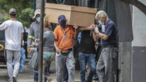 אנשים סוחבים ארון קבורה מקרטון בדרך לבית העלמין בעיר גוויאקיל, אקוודור. 6 באפריל 2020.  (AP Photo/Luis Perez)