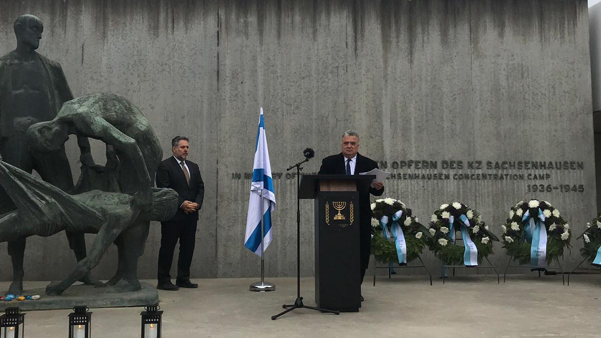 שגריר ישראל בגרמניה ג'רמי יששכרוף נואם בטקס יום השואה של השגרירות שנערך במחנה זכסנהאוסן בשנה שעברה, 2 במאי 2019 (קרדיט: יפתח בארי/ שגרירות ישראל בגרמניה)