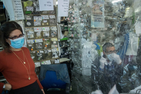 עובדים מאחורי וילון פלסטיק בחנות שנפתחה לאחר ההקלות בסגר. 19 באפריל. למצולמים אין קשר לכתבה (צילום: יונתן זינדל/פלאש90)