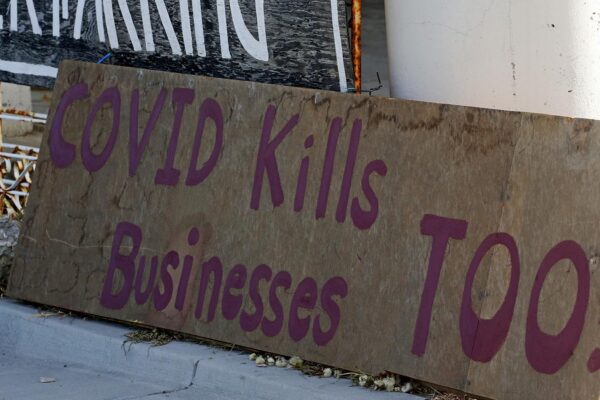 שלט "קורונה גם הורגת עסקים" שנתלה מחוץ לחנות שנסגרה בעיר סולט לייק סיטי בארצות הברית (צילום: AP Photo/Rick Bowmer)