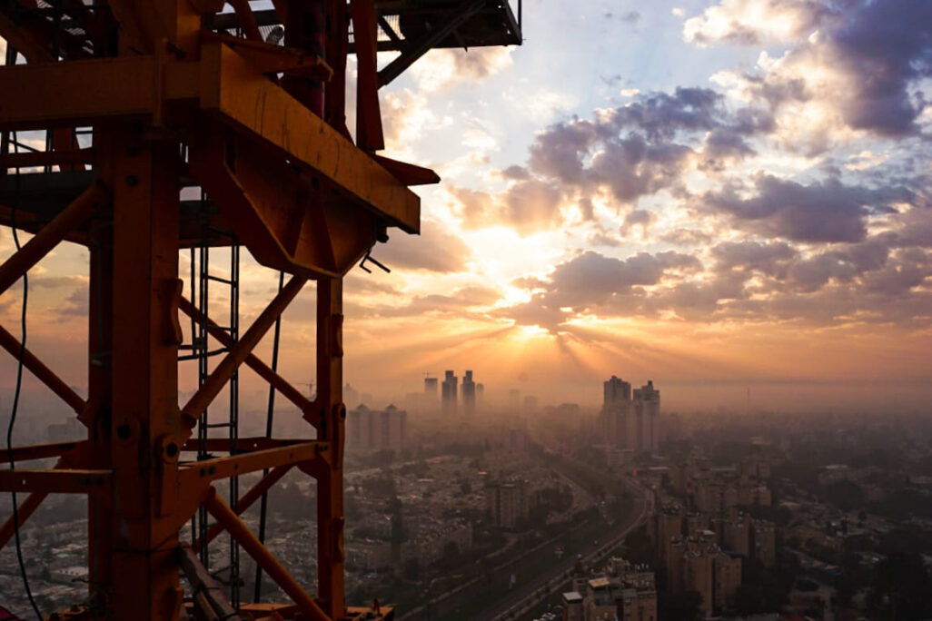The crane operator works in solitude. Sits in a small cabin, hoisted 50-100 meters above the ground, for upwards of 12 hours. (Photograph: Nisim Lalush)