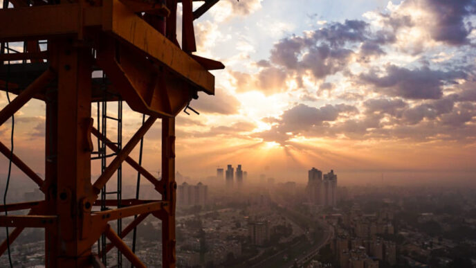 The crane operator works in solitude. Sits in a small cabin, hoisted 50-100 meters above the ground, for upwards of 12 hours. (Photograph: Nisim Lalush)