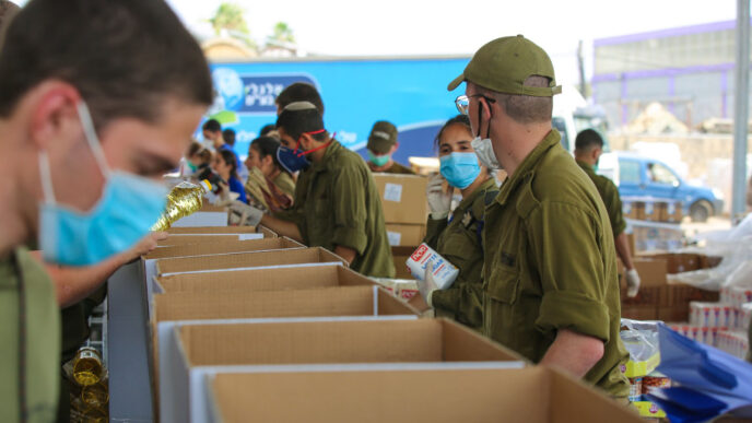 חיילים אורזים חבילות מזון במרכז הסיוע לאזרח של פיקוד העורף (קרדיט: דובר צה&quot;ל)