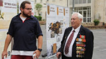 אברהם גרינזייד ואיליה מיינשלוס. ברקע: התערוכה שיצרו מיינשלוס ושותפיו העוסקת בסיפור הגבורה של לוחמי ולוחמות הצבא האדום היהודים (צילום: עיריית ראשון לציון)
