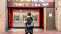 אישה עוברת ליד כספומט של Bank of America (צילום: Alex Tai/SOPA Images/LightRocket via Getty Images)