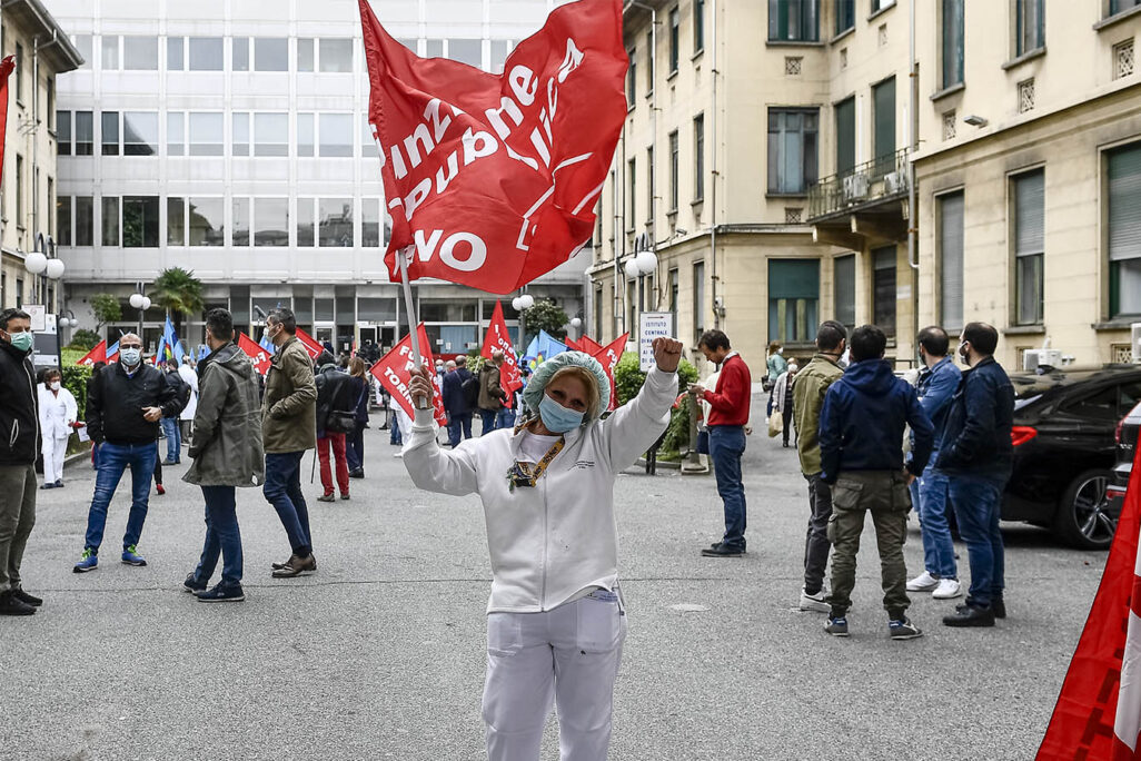 MOLINETTE HOSPITAL, TURIN, ITALY - 2020/04/30: A medical worker waves a flag during a medical workers protest organized by CGIL and UIL trade unions against dysfunctions in the Piedmont region's מטפלים מפגינים באיטליה למען שיפור תנאי עבודתם והגנה עליהם בימי הקורונה. (Photo by Nicolò Campo/LightRocket via Getty Images)