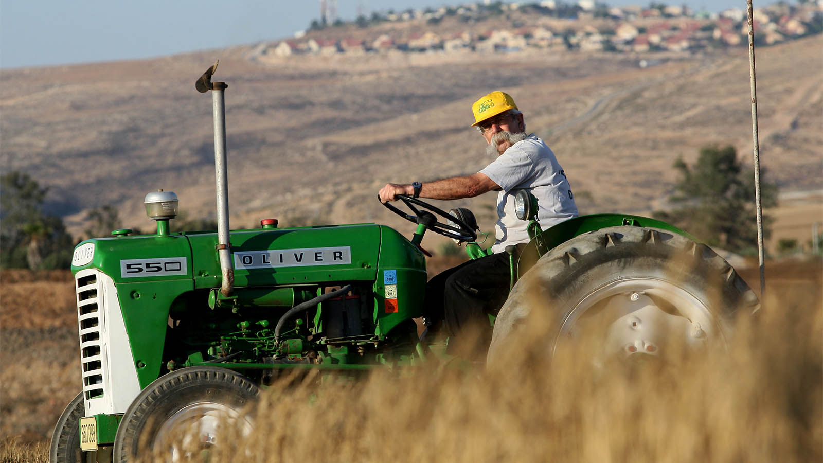 חקלאי על טרקטור בשדה בקיבוץ להב (צילום ארכיון: משה שי/פלאש90)