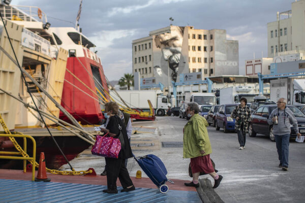 נוסעות עולות למעבורת בנמל פיראוס ביוון. (צילום: AP Photo/Petros Giannakouris)