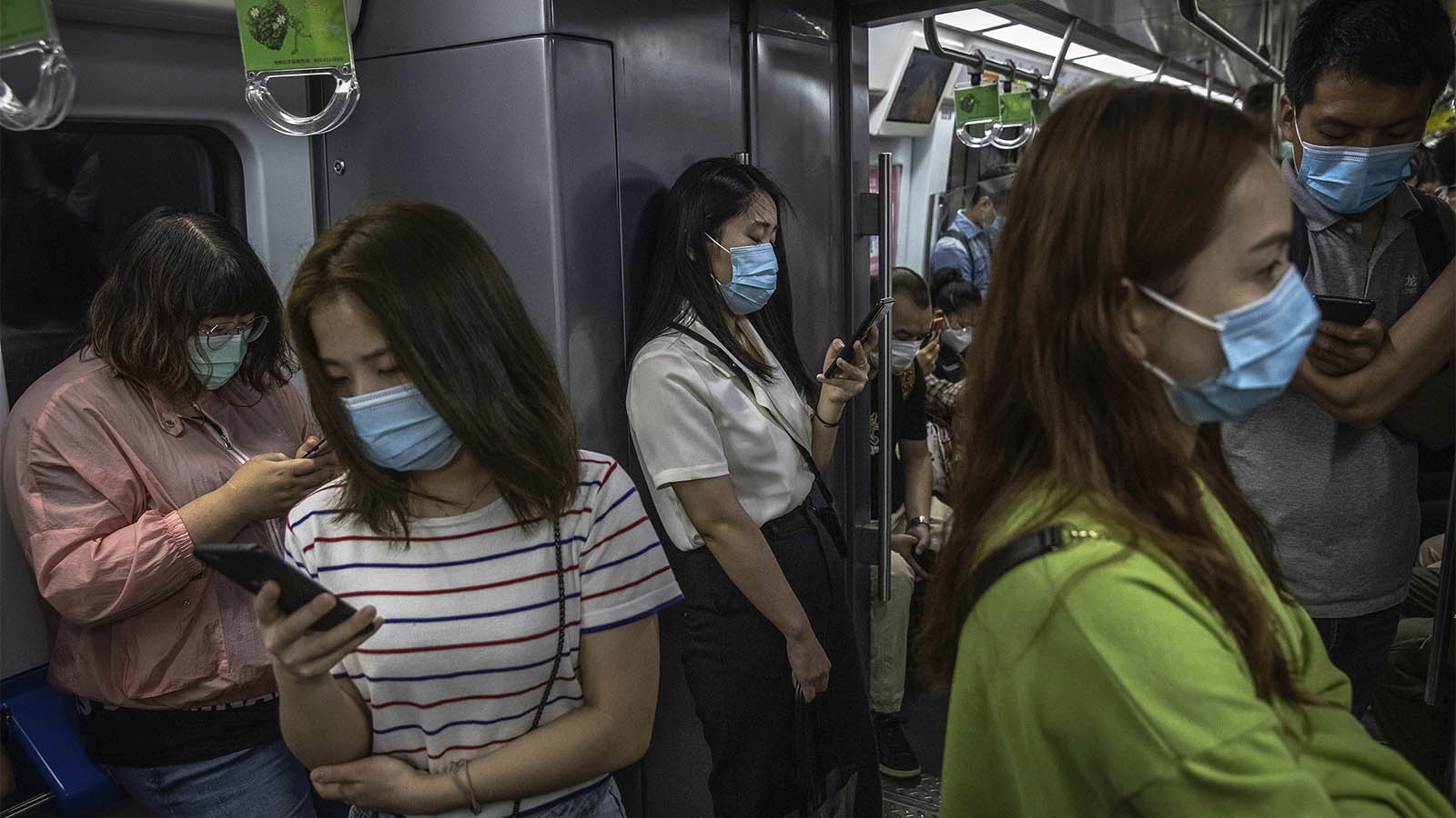 צעירים ברכבת תחתית בסין (צילום: Roman Pilipey/Pool Photo via AP).