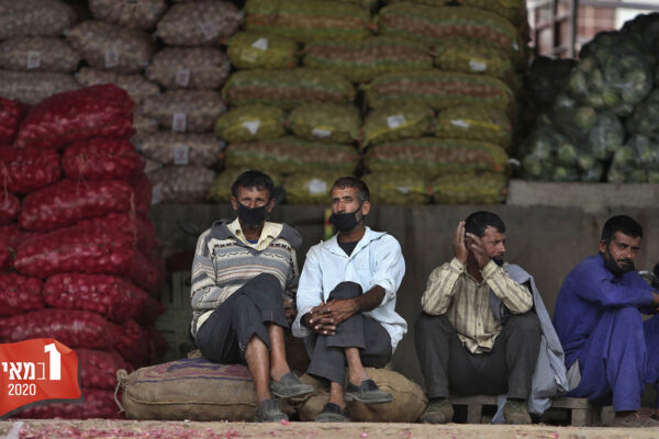 חקלאים בהודו מנסים למכור את התוצרת החקלאית שלהם בשוק בזמן עוצר בשל מגפת הקורונה. 20 באפריל (AP Photo/Channi Anand)