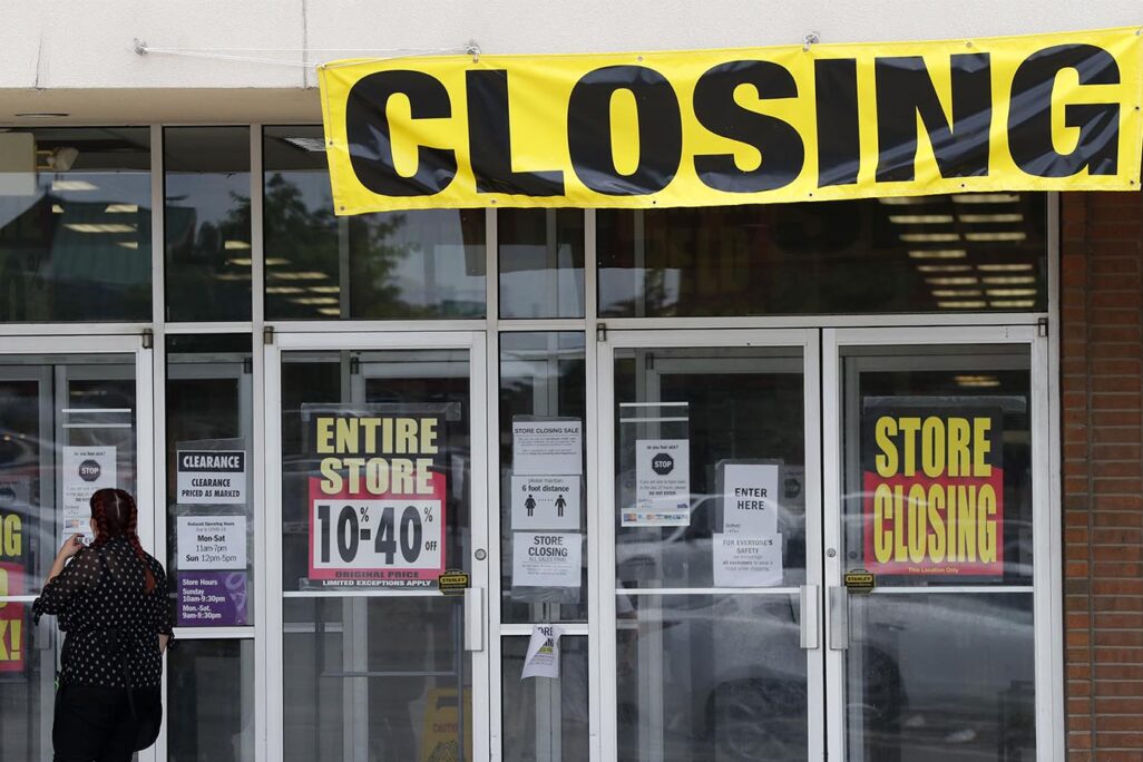 לקוחה עומדת בכניסה לחנות שנסגרה בשל פשיטת רגל במיזורי ארה"ב. 28 במאי (AP Photo/Jeff Roberson)