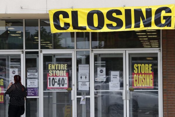 לקוחה עומדת בכניסה לחנות שנסגרה בשל פשיטת רגל במיזורי ארה"ב. 28 במאי (AP Photo/Jeff Roberson)