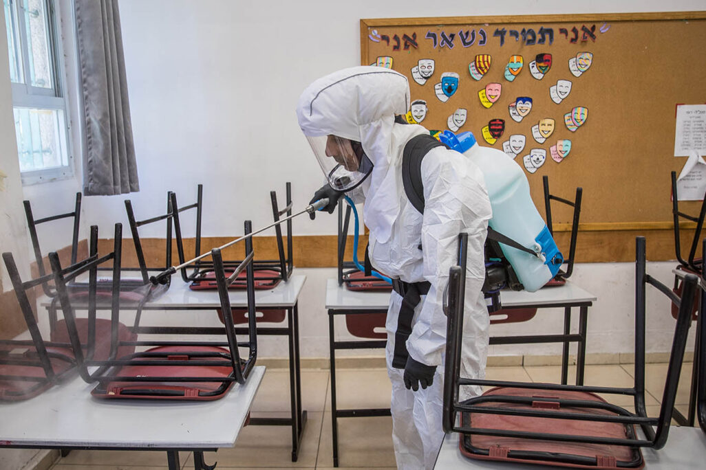 עובד תברואה מחטא כיתה בתיכון גימנסיה רחביה בירושלים (צילום: יונתן זינדל/פלאש90)