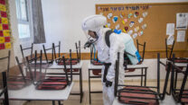 עובד תברואה מחטא כיתה בתיכון גימנסיה רחביה בירושלים (צילום: יונתן זינדל/פלאש90)