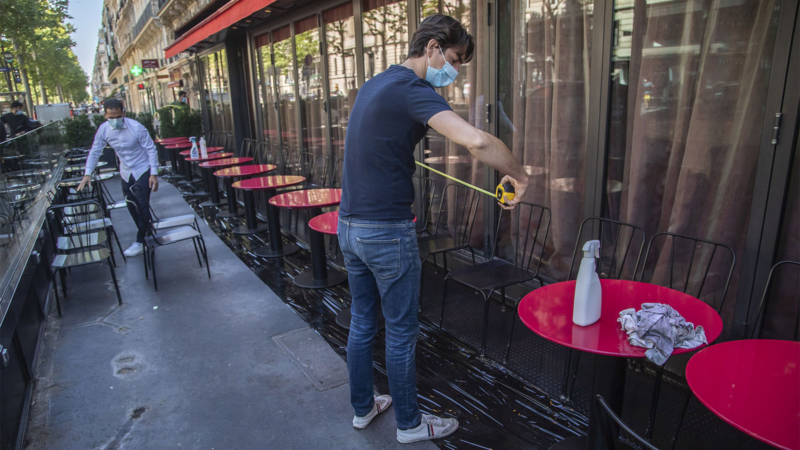 פייר-אנטוני בורו מודד את המרחקים בין השולחנות בחצר מסעדה בפריז כחלק מההכנות לפתיחה המחודשת (AP Photo/Michel Euler)