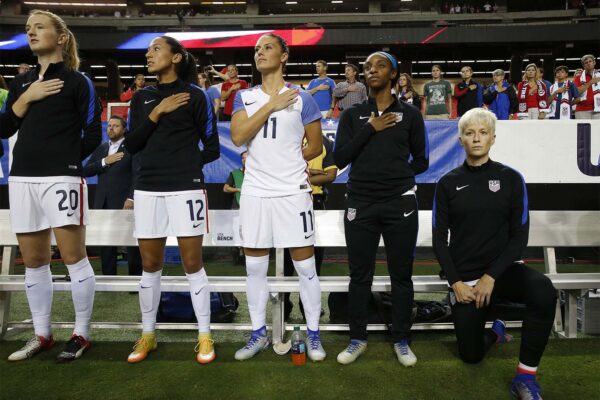 שחקנית הכדורגל מייגן ראפינו, כורעת ברך בהשמעת ההמנון האמריקני לפני משחק נבחרת ארה:ב נגד הולנד. 18 בספטמבר 2016  (AP Photo/John Bazemore)