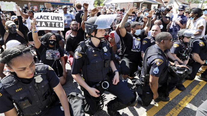 שוטרים בעיר קליבלנד כורעים ברך יחד עם מפגינים כמחאה על רצח ג'ורג' פלויד בזמן הפגנה (צילום: AP Photo/Tony Dejak).