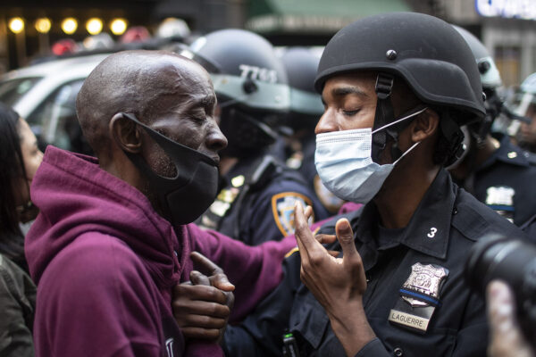 מפגין ושוטרת בניו יורק מתחבקים לאות הזדהות בזמן הפגנה בעקבות הרצח של ג'ורג' פלויד (צילום: AP Photo/Wong Maye-E, File).