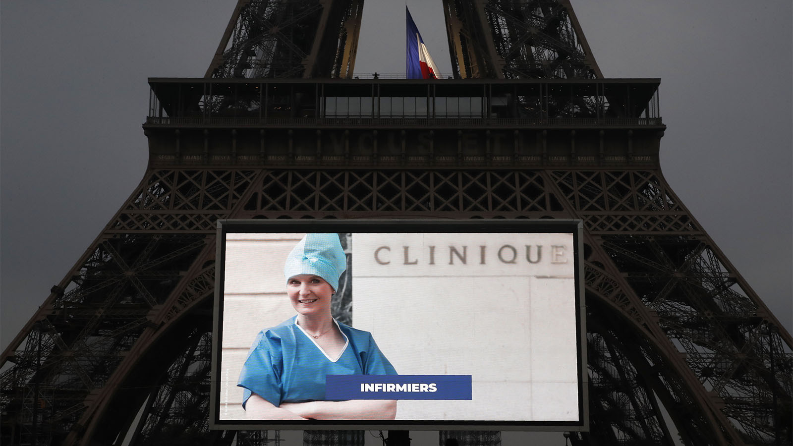תמונה של אחות מוקרנת על מגדל האייפל בפריז, כמחווה לעובדי מערכת הבריאות בצרפת במהלך מגפת הקורונה. 10 במאי (AP Photo/Christophe Ena)