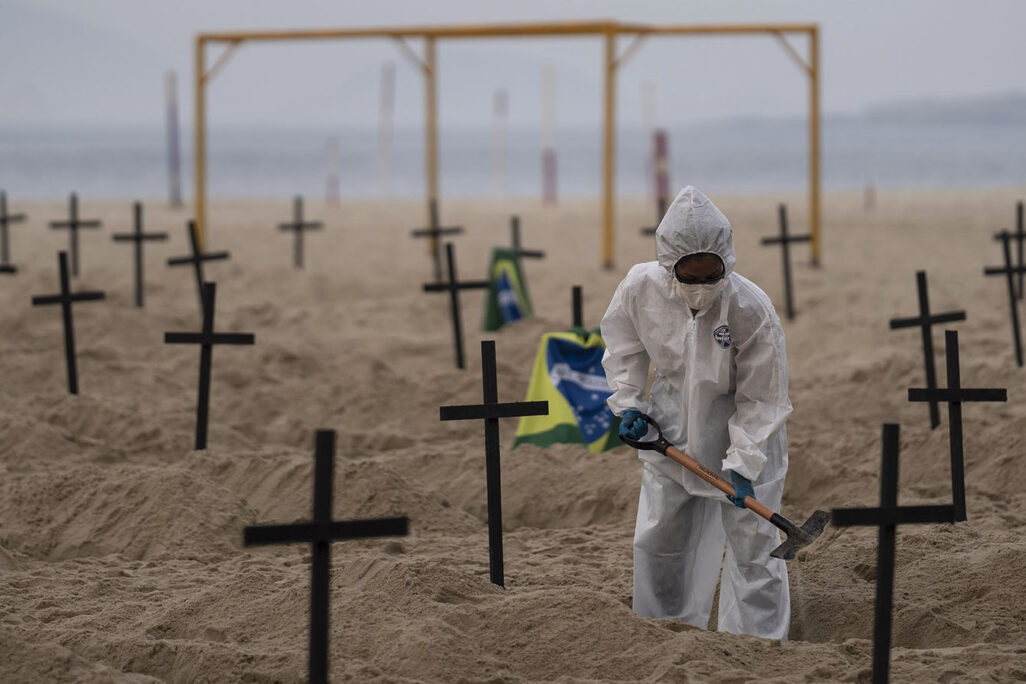 פעילה חברתית חופרת קברים ריקים בחוף הקופוקבנה בברזיל כמיצג אומנותי מחאתי נגד מדיניות ממשלת ברזיל. 11 ביוני (AP Photo/Leo Correa)