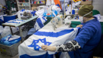 עובדת עם מסכה נגד קורונה במפעל לייצור דגלים, לקראת יום העצמאות. 27 באפריל. (צילום: יונתן זינדל/פלאש90)