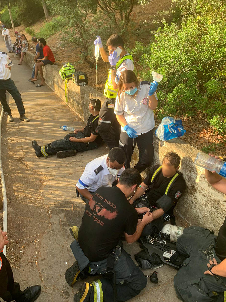 כבאים מקבלים טיפול רפואי במהלך אירוע שריפה בחיפה (מתוך דף הפייסבוק של ארגון הכבאים)