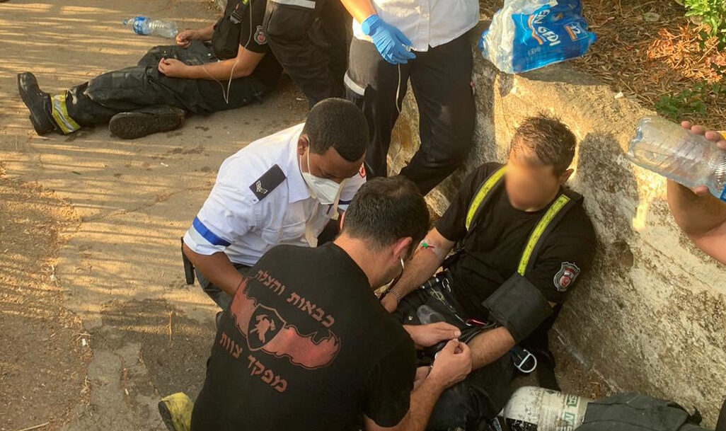 כבאים מקבלים טיפול רפואי במהלך שריפה בבניין בחיפה (מתוך דף הפייסבוק של ארגון הכבאים)