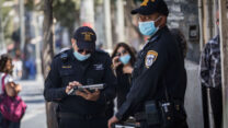שוטרים מחלקים דו״חות על אי עטיית מסכות בירושלים (צילום: יונתן זינדל/פלאש90)