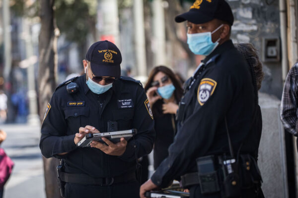 שוטרים מחלקים דו״חות על אי עטיית מסכות בירושלים (צילום: יונתן זינדל/פלאש90)
