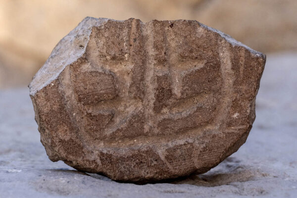 חותם עשוי שבר כלי חרס גדול מהתקופה הפרסית. (צילום: שי הלוי, רשות העתיקות)