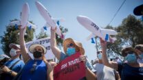 עובדי ענף התיירות מפגינים מול הכנסת ונושאים דגמי מטוסים שעה שמטוס של חברת ישראייר חג מעליהם (צילום: יונתן זינדל/פלאש90)