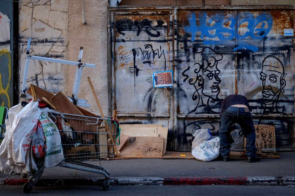 A man looks through garbage in Tel Aviv.  November 12, 2019. (Photograph: Sara Klatt/FLASH90)