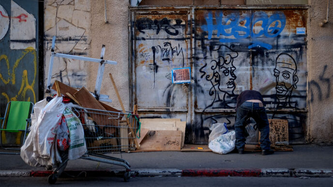 A man looks through garbage in Tel Aviv.  November 12, 2019. (Photograph: Sara Klatt/FLASH90)