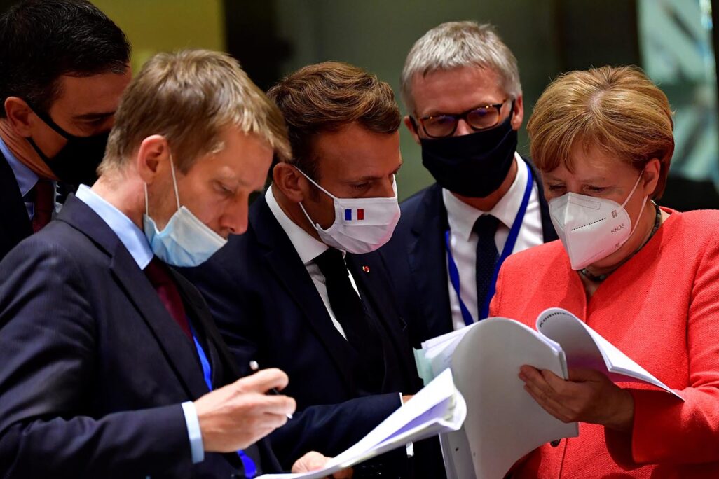 קנצלרית גרמניה אנגלה מרקל ונשיא צרפת עמנואל מקרון מעיניים בתכנית הכלכלית של האיחוד האירופי במהלך ועידת האיחוד. 20 ביולי (John Thys, Pool Photo via AP)