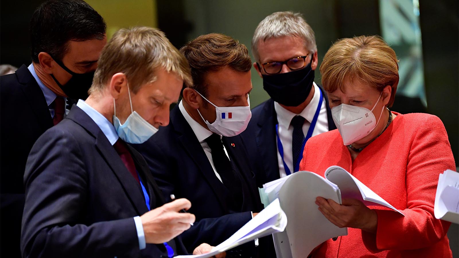 קנצלרית גרמניה אנגלה מרקל ונשיא צרפת עמנואל מקרון קוראים את התכנית הכלכלית של האיחוד האירופי במהלך ועידת האיחוד (John Thys, Pool Photo via AP)