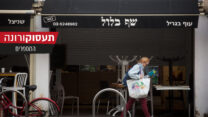 אישה עוברת מול מסעדה סגורה בתל אביב (צילום: מרים אלטשר/פלאש90)