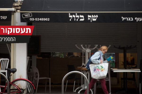 אישה עוברת מול מסעדה סגורה בתל אביב (צילום: מרים אלטשר/פלאש90)
