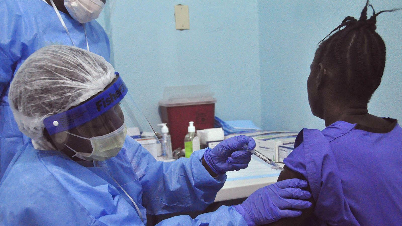 אשה מקבלת זריקה במסגרת ניסויים בחיסון לנגיף האבולה שקטל קרוב ל-9,000 בני-אדם במערב אפריקה. מונרוביה, ליבריה. ה-2 בפברואר 2015(AP Photo/ Abbas Dulleh)