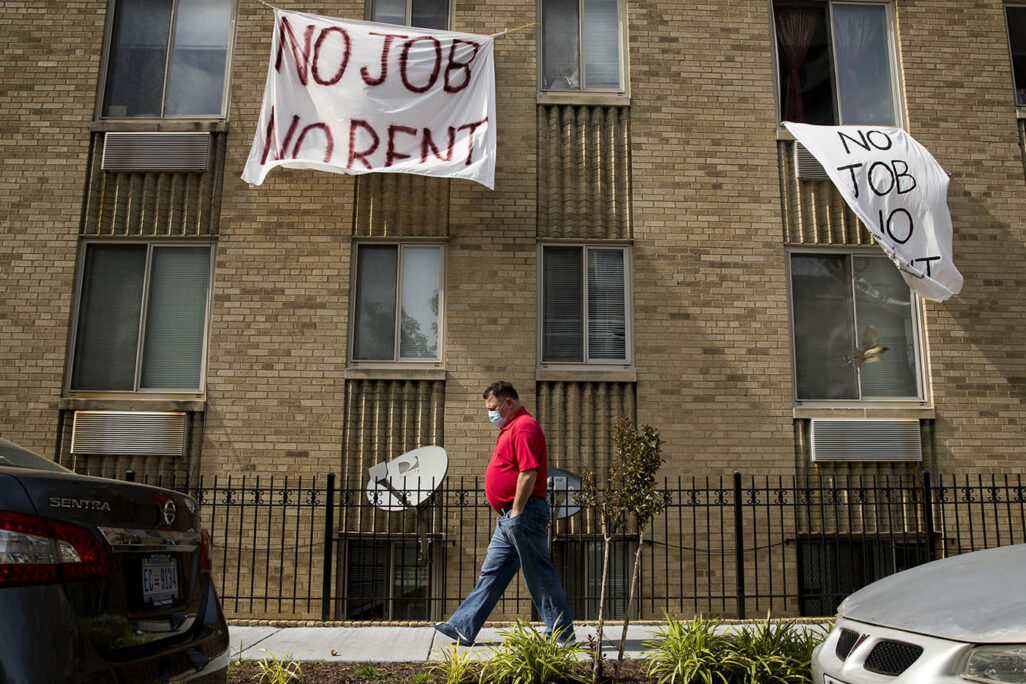 שלטים שכתוב בהם "אין עבודה אין שכר דירה" תלוים על בניין מגורים בארה"ב (צילום: AP Photo/Andrew Harnik, File)