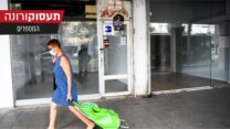 אישה הולכת ברחוב מול חנויות סגורות במרכז תל אביב. 11 באוגוסט. (צילום: פלאש90)