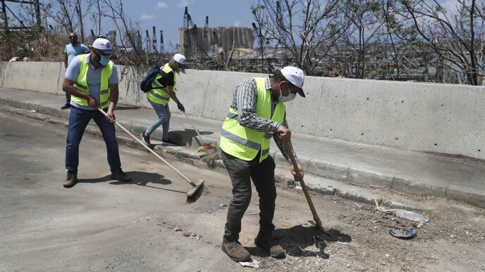 מתנדבים שהגיעו ממזרח לבנון לסייע במאמצי השיקום של ביירות מנקים את אחד הרחובות סמוך לזירת הפיצוץ בנמל בעיר הבירה. (צילום: (AP Photo/Hussein Malla
