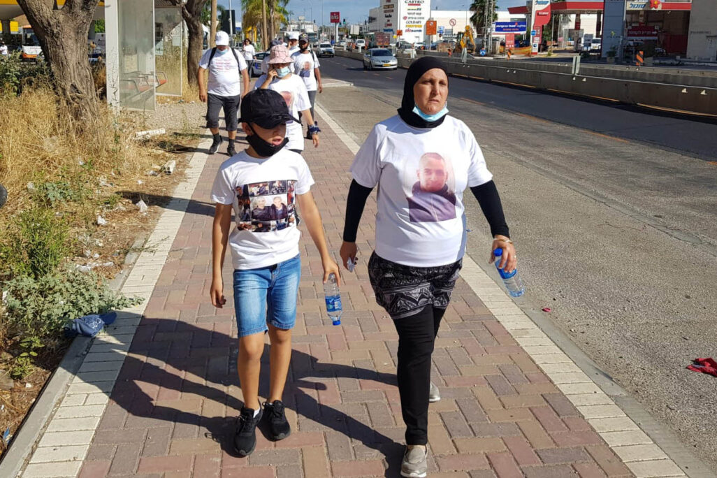 منى خليل، التي قُتل ابنها في مدينة حيفا، تسير مع حفيدها في اطار ‘مسيرة الأمهات ضد العنف‘. (تصوير: يائير فيطمان)