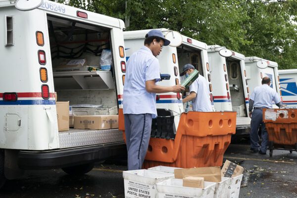 עובדי דואר מעמיסים דברי דואר על משאיות במרכז הדואר במקלין, וירג'יניה (AP Photo/J. Scott Applewhite)