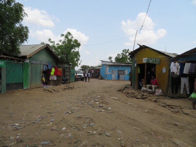 חנויות במחנה פליטים קאקומה שבצפון קניה, השלטים מעידים שניתן לשלם במוביל מאני, אוגוסט 2018 (צילום: חגית פרויד)