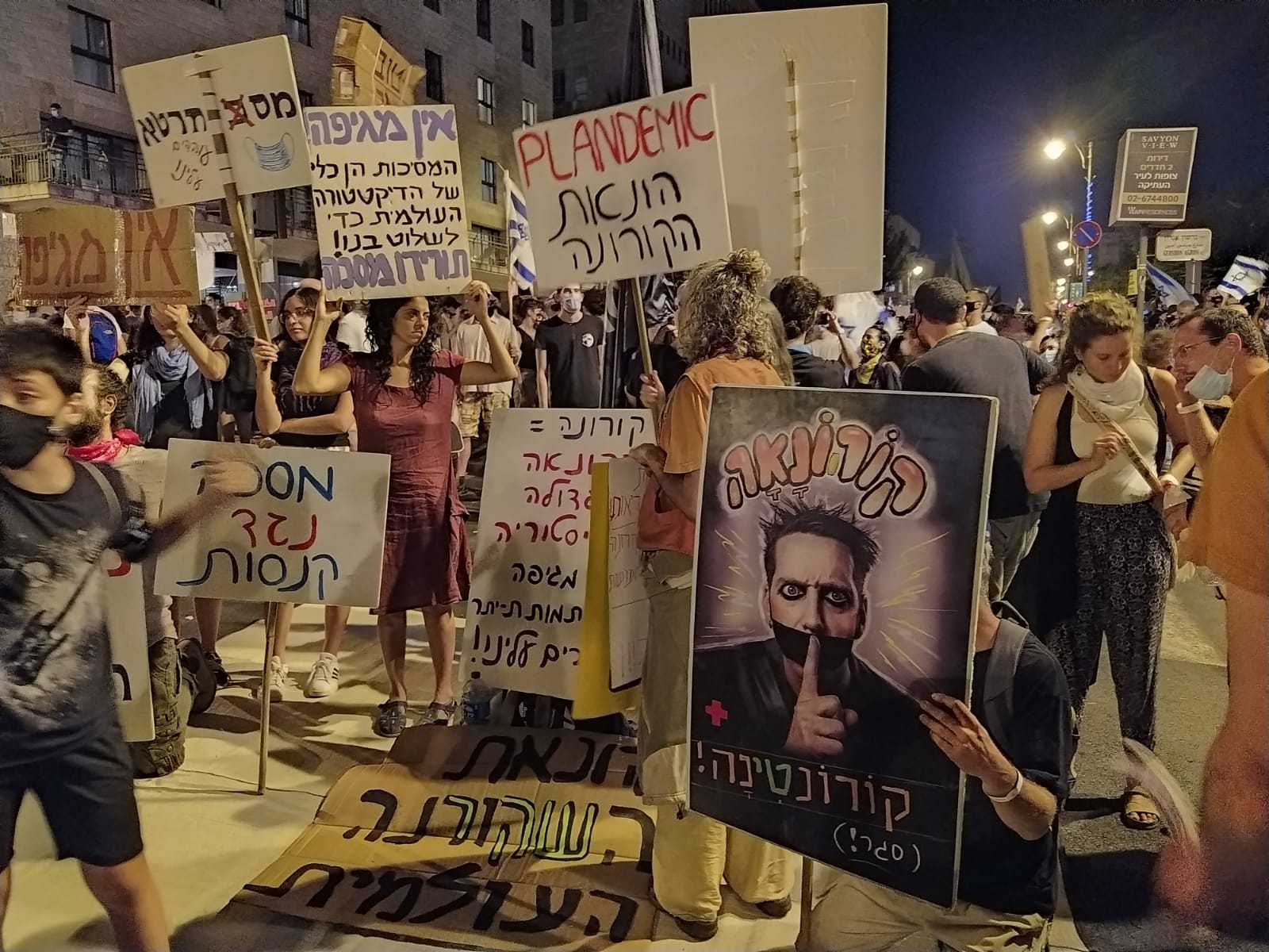 מפגינים נושאים שלטים נגד 'הונאת הקורונה' בהפגנה נגד מדיניות הממשלה בכיכר פריז בירושלים, 15 באוגוסט 2020 (צילום: יהל פרג')