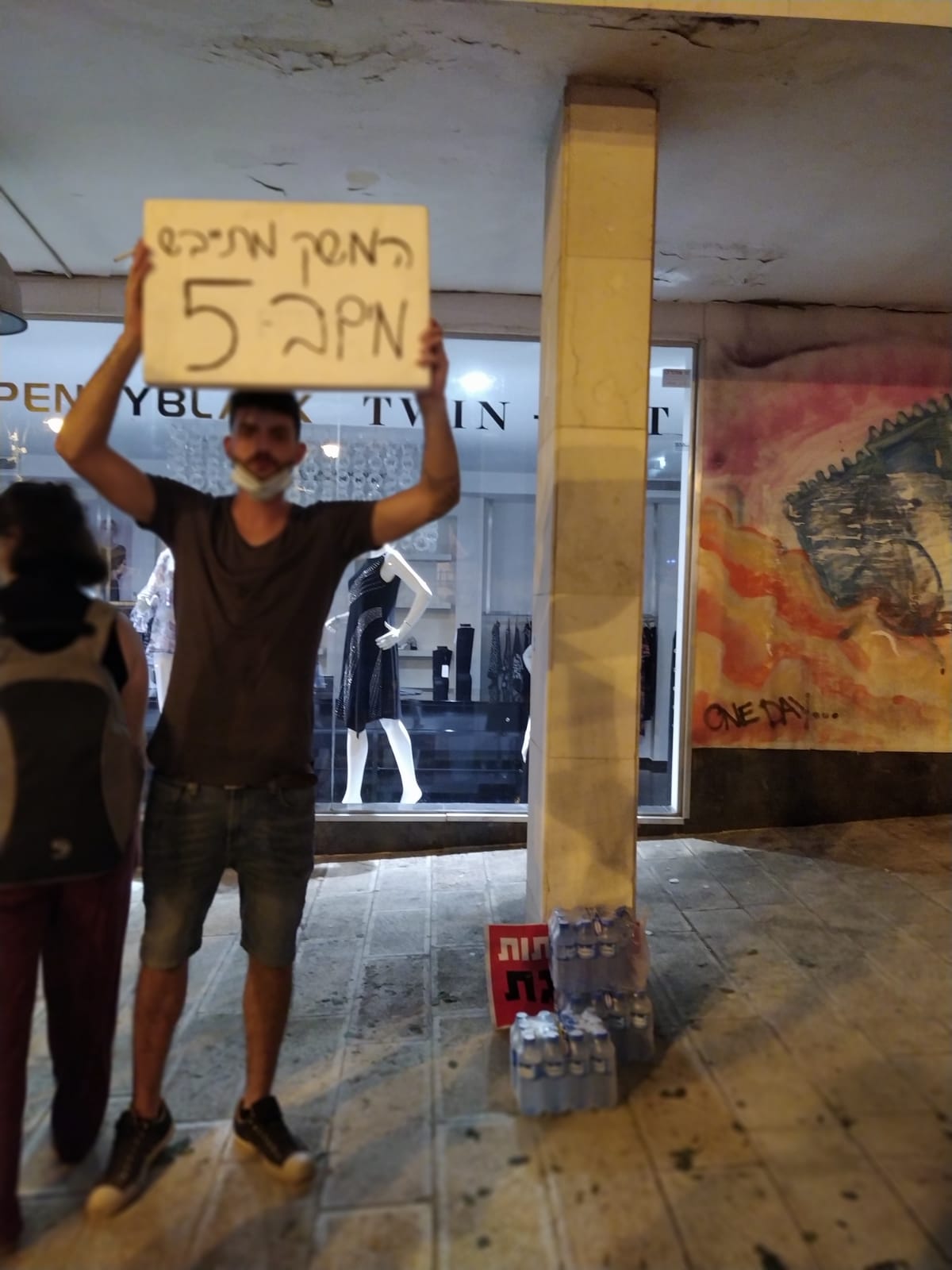 מוכר בקבוקי מים בהפגנת מחאה נגד מדיניות הממשלה בירושלים, 15 באוגוסט 2020 (צילום: יהל פרג')