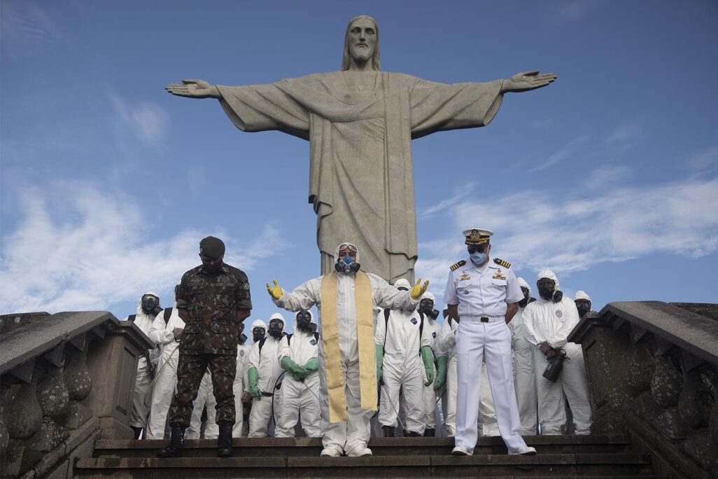 כומר קתולי מוביל תפילה בהשתתפות חיילים שעסקו בעבודות חיטוי בפסל ישו הגואל בריו דה ז'נרו, ברזיל. 13 באוגוסט 2020 (AP Photo/Silvia Izquierdo)