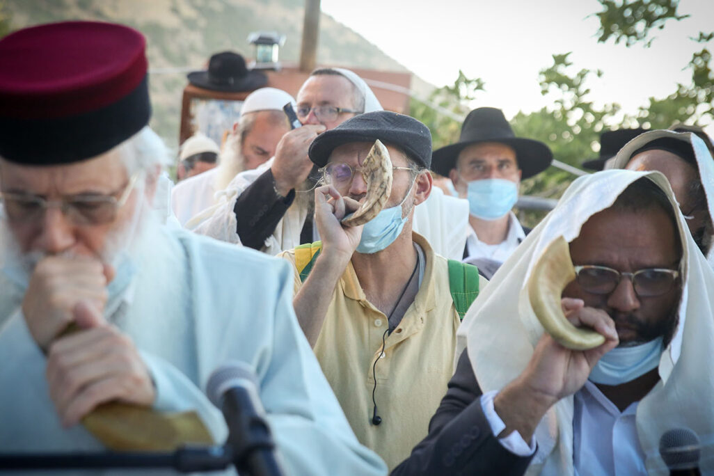 Men blow shofars during a ״Thousand Shofarot Tikkun״ prayer ceremony at the grave of Rabbi Yonatan ben Uziel, in the Northern Israeli community of Amuka, June 18, 2020. Photo by David Cohen/Flash90