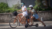רוכבת אופניים ורוכבת קורקינט ממונע (צילום: מרים אלטשר/פלאש90)