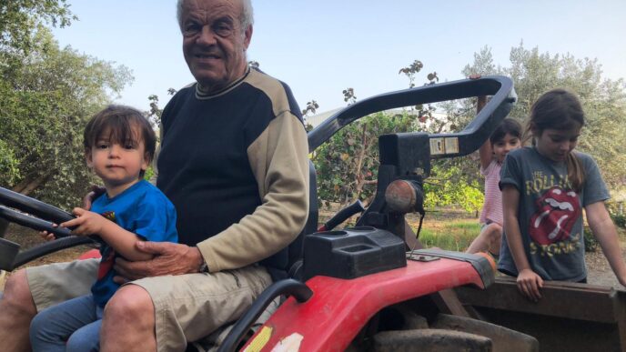 Eli Rokach takes his grandchildren for a ride on the tractor. (Photo: private album)